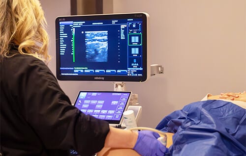 Una sonografista de Empire Vein & Vascular realizando una revisión de venas con ultrasonido